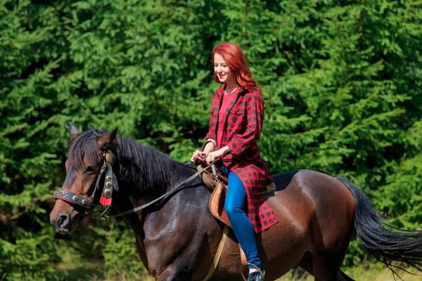 夏の緑の森に馬と赤毛の女の子 — ストック写真