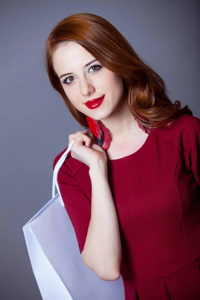 Rothaarige Frau Roten Kleid Mit Einkaufstasche Auf Grauem Hintergrund — Stockfoto