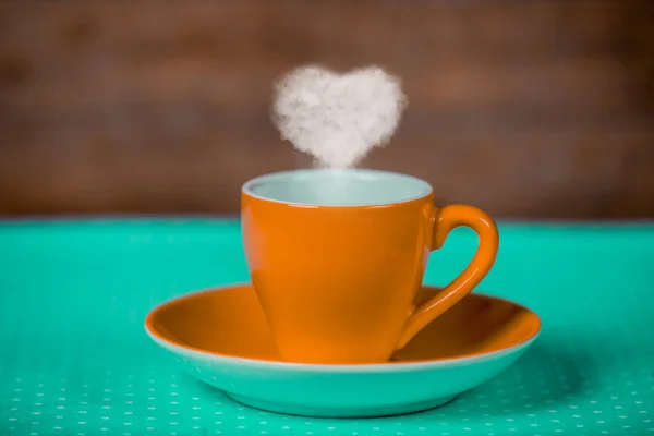 Taza Café Naranja Con Vapor Forma Corazón Sobre Mesa Turquesa —  Fotos de Stock