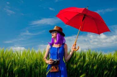 Beautiful purple hair girl with umbrella at wheat field in summertime season clipart