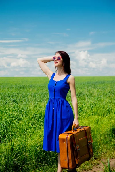 夏のシーズンに麦畑でスーツケース立って美しい赤毛の女の子 — ストック写真