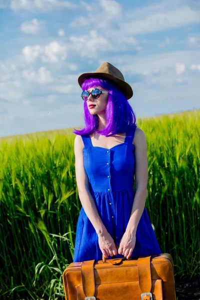 夏天的麦田里美丽的紫色头发女孩与手提箱 — 图库照片