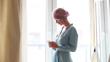 Genç kız evde bir cep telefonu kullanarak kısa kıllar ile bere içinde