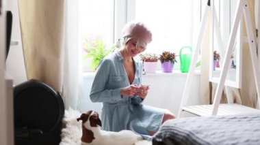 Genç kız pembe saçlı ve bere ile köpek vasıl ev telefonu kullanarak. Trendy tarzı kıyafetler 