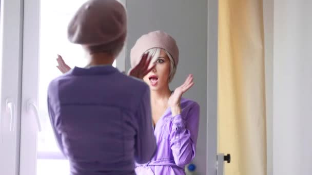 年轻的女孩在贝雷帽与短头发打扮在附近的镜子在家 — 图库视频影像