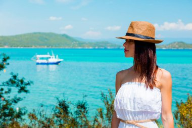 bir şapka bir botla denize yakın poz kız