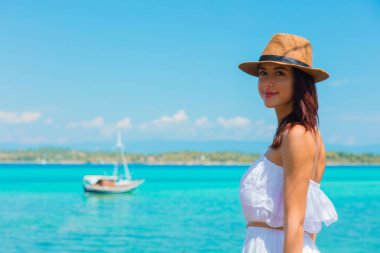 bir şapka bir botla denize yakın poz kız