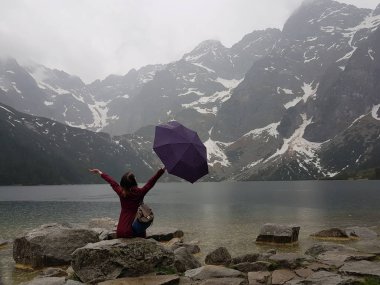 Lake yakınındaki kayalarda oturup şemsiye ile kız