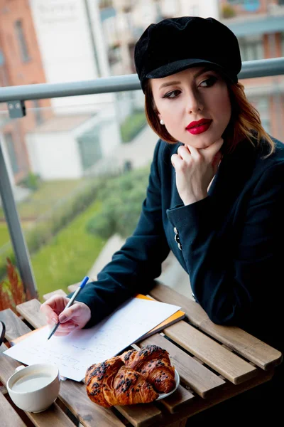 Young redehad girl in black clothes have a breakfast — Stock Photo, Image