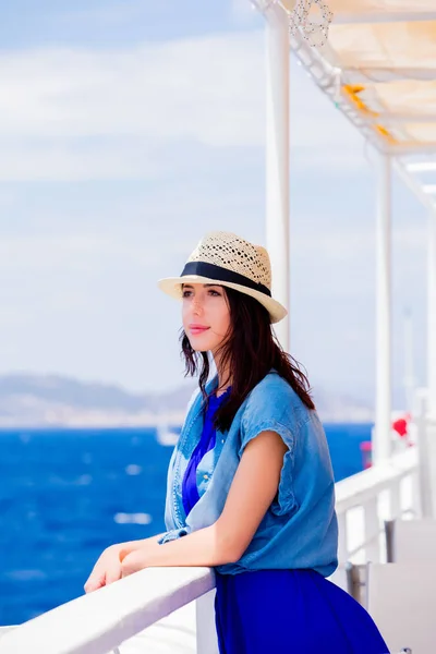 Girl in blue dress and hat have a voyage on a boat — Stock Photo, Image