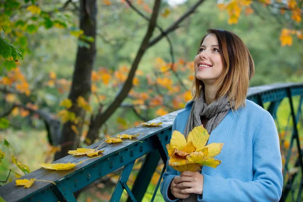 Dívka v kabátu a klobouku v parku. — Stock fotografie