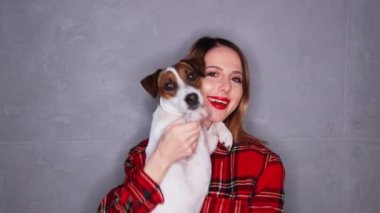 Gülümseyen ve gri arka plan üzerinde köpek sarılma kadın