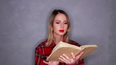 Güzel kadın gri arka plan üzerinde kitap okuma