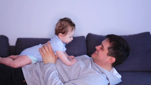 Feliz Padre Acostado Cama Sosteniendo Pequeño Hijo Divertirse — Vídeo de stock