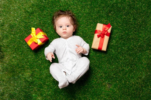 Niño Bonito Con Regalos Acostado Hierba Verde — Foto de Stock