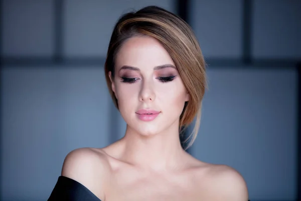 Young woman with makeup in black dress — Stock Photo, Image