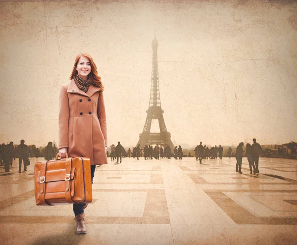 Рыжая женщина с чемоданом приезжает в Париж. — стоковое фото