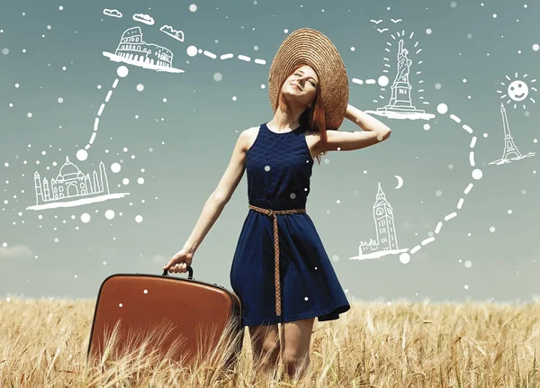 Redhead girl with suitcase at spring wheat field. — Stock Photo, Image