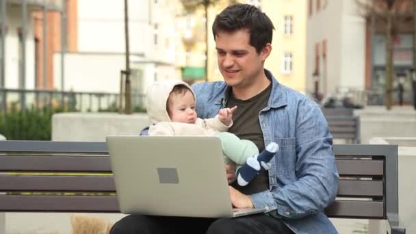 Joven padre con un niño tratar de woking con la computadora — Vídeo de stock gratis