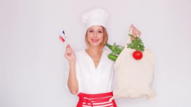 厨师制服的妇女与不同的菜和法国旗子的袋子 — 图库视频影像