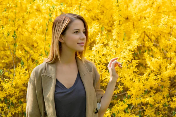 Vrouw stond in de buurt van blossom geel bush — Stockfoto