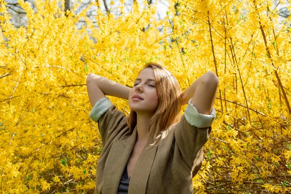 Vrouw stond in de buurt van blossom geel bush — Stockfoto