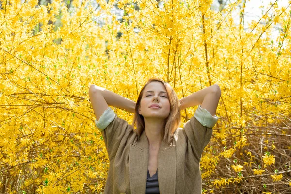 Vrouw stond in de buurt van blossom geel bush — Stockfoto