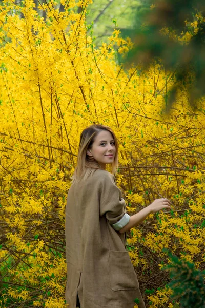 Donna in piedi vicino a fiore cespuglio giallo — Foto Stock