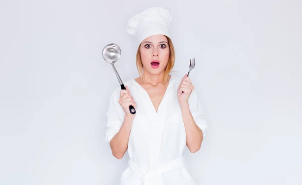 Frau in Kochuniform hält Geschirr in der Hand — Stockfoto
