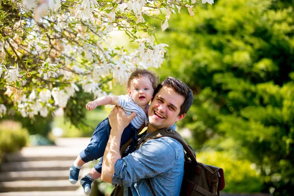 Vader met kind hebben een recreatieve bloeiende tuin — Stockfoto