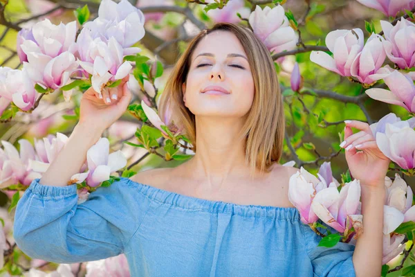 Meisje in bloesem magnolia tuin. — Stockfoto