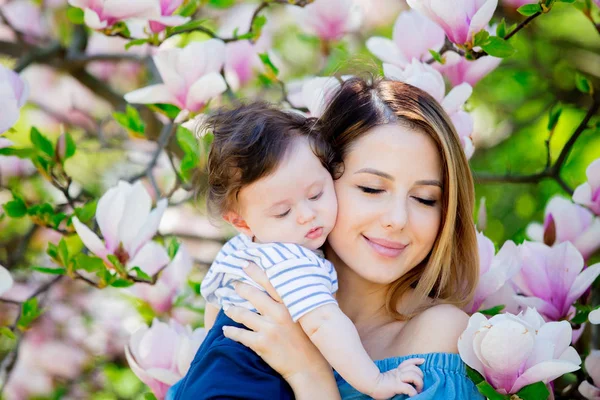Matka i dziecko mają lasure w Magnolia garden — Zdjęcie stockowe