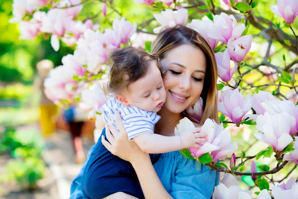 Matka i dziecko mają lasure w Magnolia garden — Zdjęcie stockowe