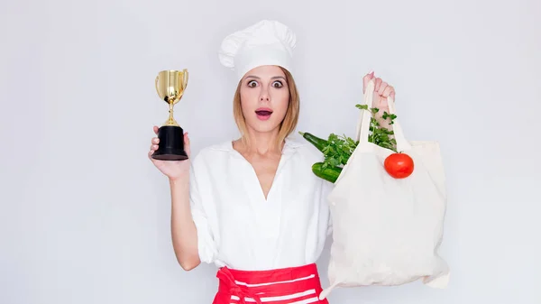 Жінка тримає сумку з овочами і призовою чашкою — стокове фото