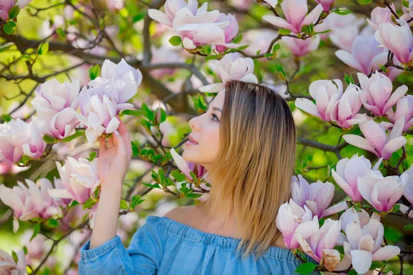 Mädchen im blühenden Magnoliengarten. — Stockfoto