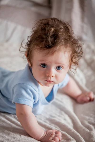 Yatakta uzanarak küçük kıvırcık çocuk çocuk — Stok fotoğraf