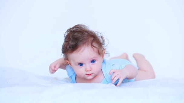 光の服でベッドに横たわる小さな赤ちゃん — ストック動画