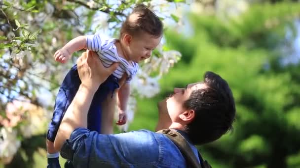 Genç Çocuk Babasıyla Güneşli Bir Günde Bahar Manolya Çiçekli Bahçe — Stok video