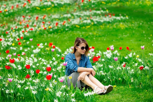 Giovane rossa ragazza seduta a tulipani prato — Foto Stock