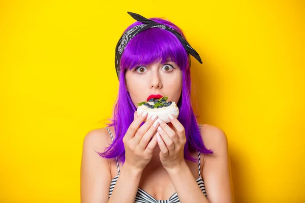 Menina com cabelo roxo segurando um bolo de creme — Fotografia de Stock