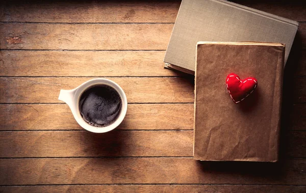 Λευκό φλιτζάνι με καφέ και βιβλία με καρδιά — Φωτογραφία Αρχείου