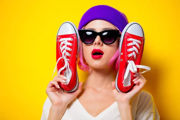 Chica con pelo rosa sosteniendo un rojo gumshoes —  Fotos de Stock