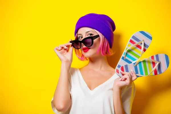 Dziewczyna w fioletowy kapelusz gospodarstwa flip flops — Zdjęcie stockowe