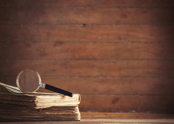 Lupe und Buch auf dem Tisch — Stockfoto