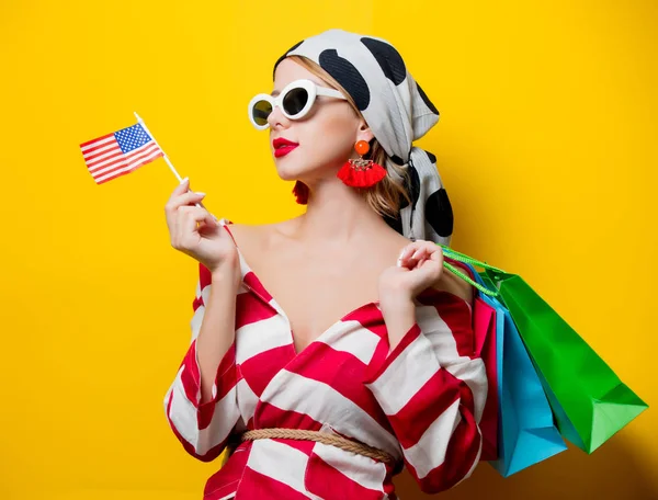 Femme avec drapeau américain et sacs à provisions — Photo