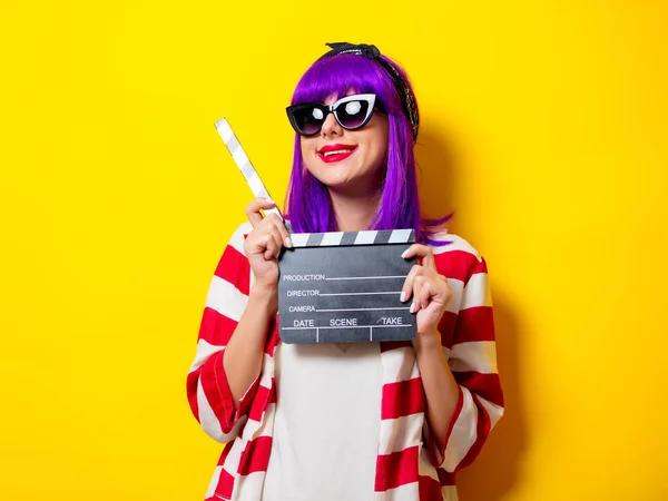 Νεαρή ηθοποιός με μοβ μαλλιά κρατώντας μια κλακέτα — Φωτογραφία Αρχείου