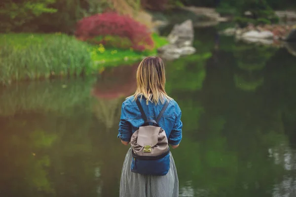 Jeune fille élégante se reposer près d'un étang — Photo