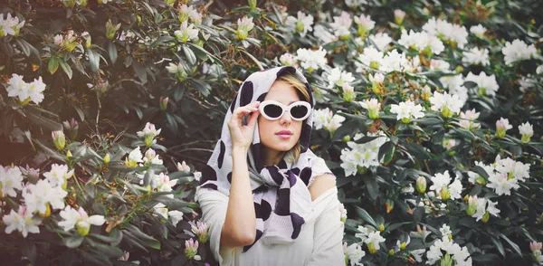 Rossa ragazza in scialle bianco vicino ai fiori — Foto Stock