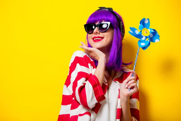 Menina com cabelo roxo segurando brinquedo pinwheel — Fotografia de Stock