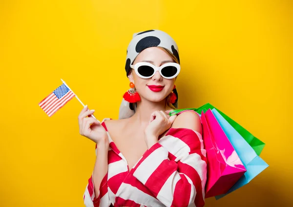 Vrouw met ons vlag en boodschappentassen — Stockfoto